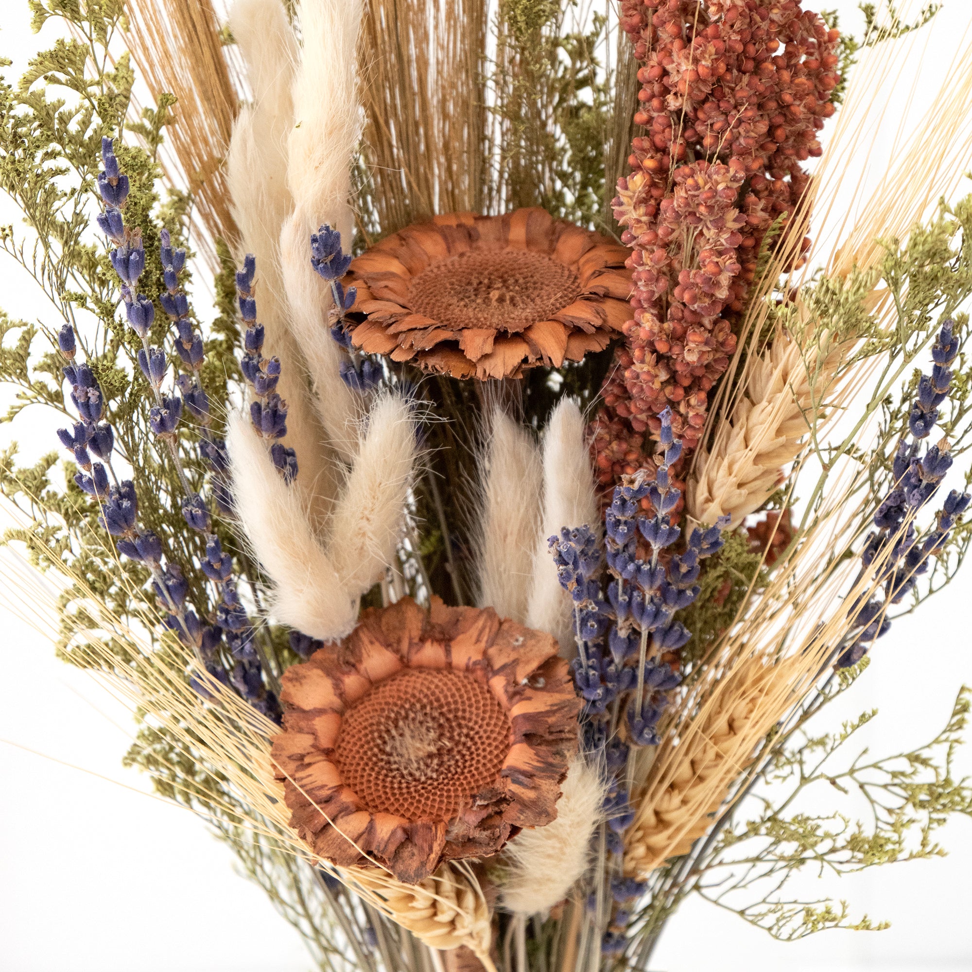 mixed white and tan dried floral bouquet against white background