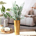 Gold vase with greenery on a coffee table in a living room setting