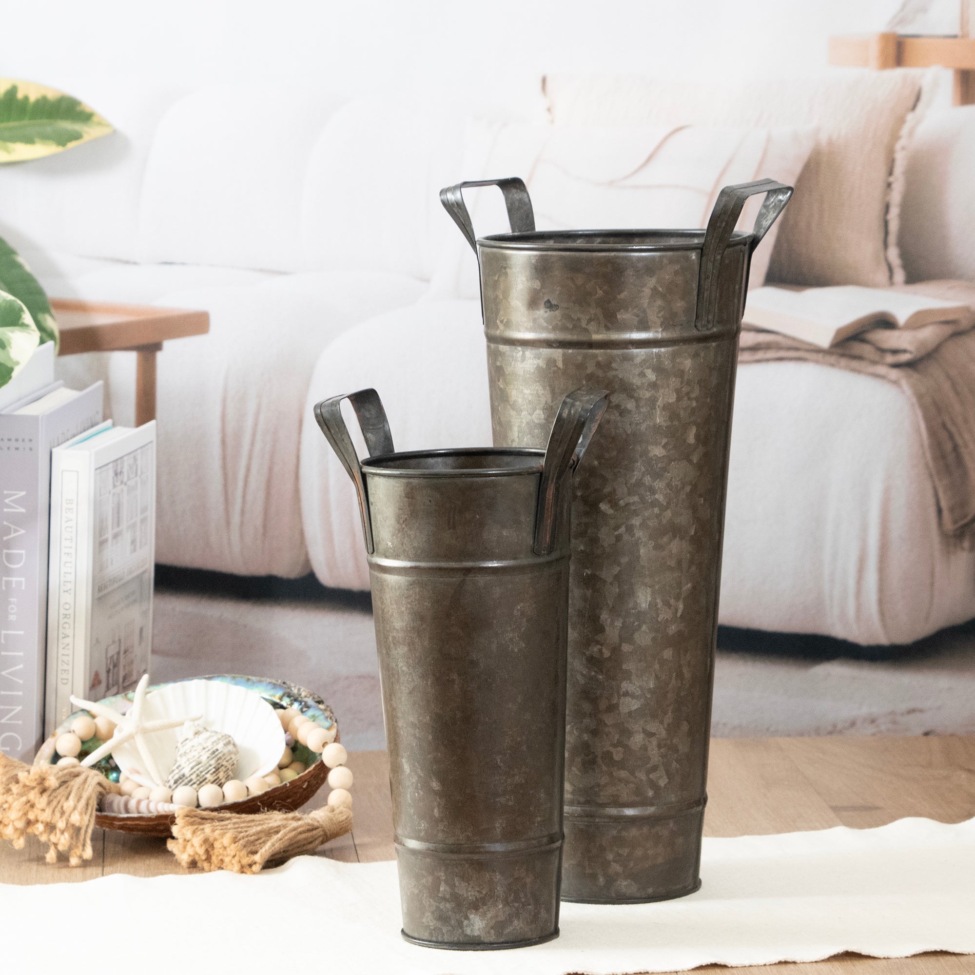 Two metallic buckets on a table with a cozy living room background