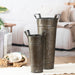 Two metallic buckets on a table with a cozy living room background