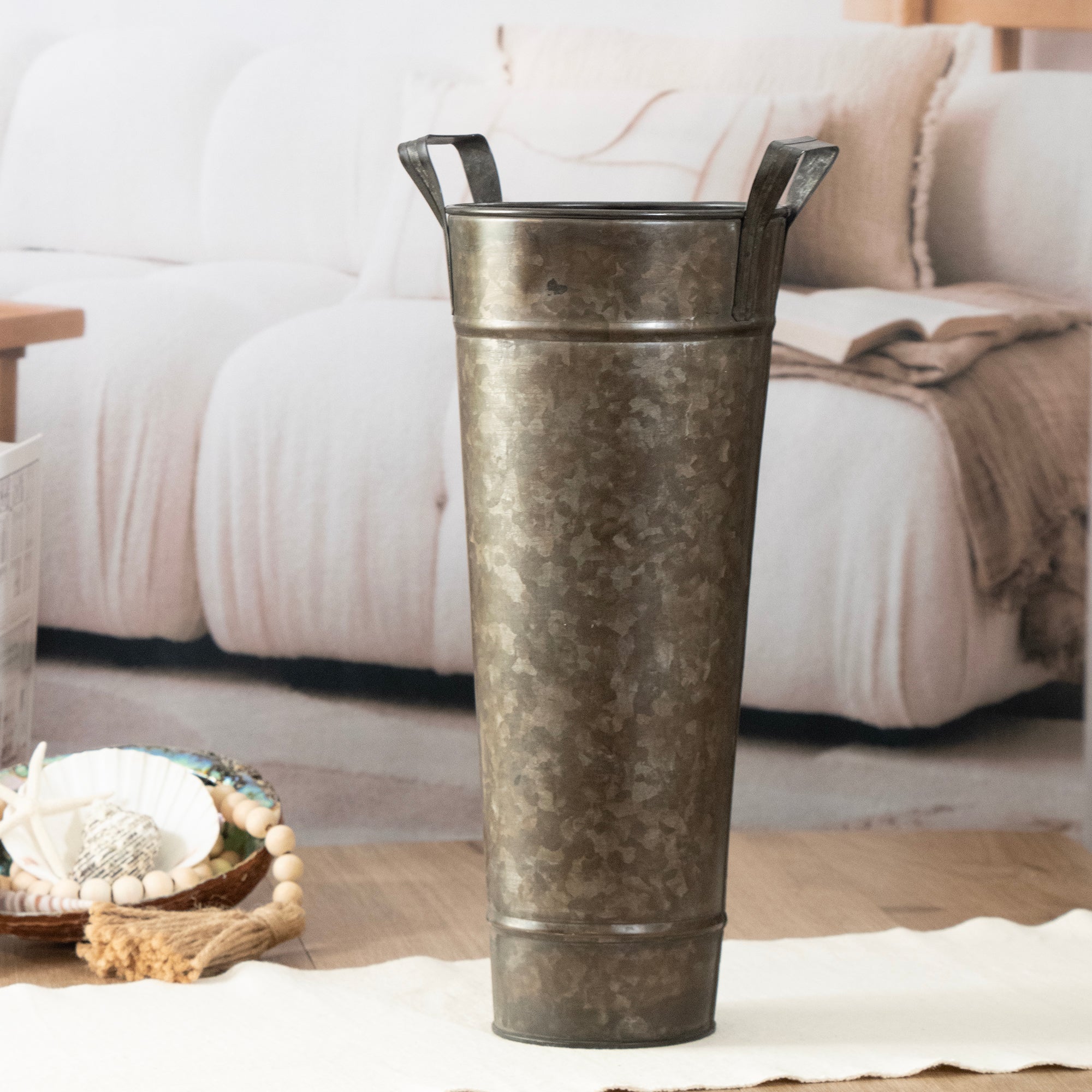 Decorative metal vase on a coffee table with a blurred sofa in the background