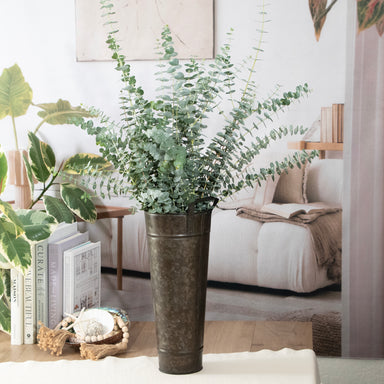 Decorative plant in a metal pot on a coffee table with a cozy living room background.