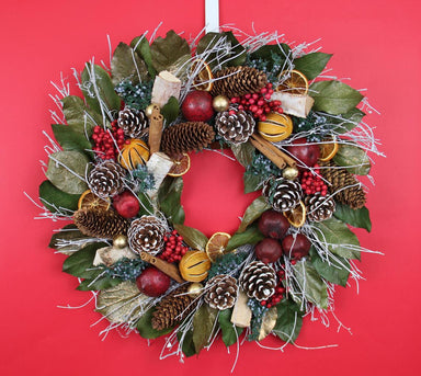 pomegranate citrus holiday wreath against red background